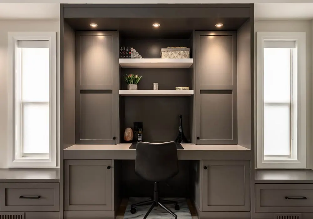 Built-in home office with painted cabinetry, floating shelves, and integrated lighting by Amend Developments